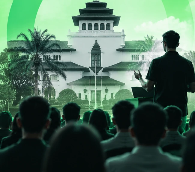 Seorang speaker membawakan sesi di depan peserta dengan latar Gedung Sate, Bandung